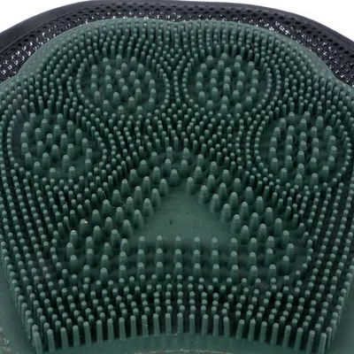 Close-up of a green rubber brush with paw-shaped studs, suitable for coat care.