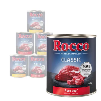 Rocco Classic Pure Beef 800g tin, visible label text: 100% fresh ingredients & grain-free. Other Rocco Classic tins in background include Pure Beef and Beef with Chicken varieties.
