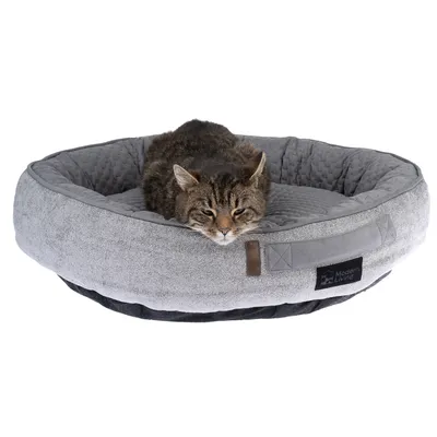 Graues, rundes Haustierbett mit weicher Polsterung und Modern Living Logo. Katze liegt entspannt im Bett.