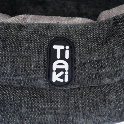 Tiaki-logotip na sivem tekstilnem materialu, podroben pogled.