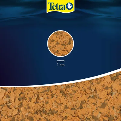 Tetra. Detailweergave van vlokkenvoer met schaal, toont vlokgrootte van 1 cm.