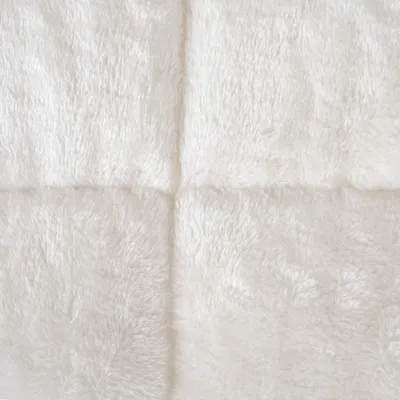 Close-up of white, soft faux fur with square quilting.