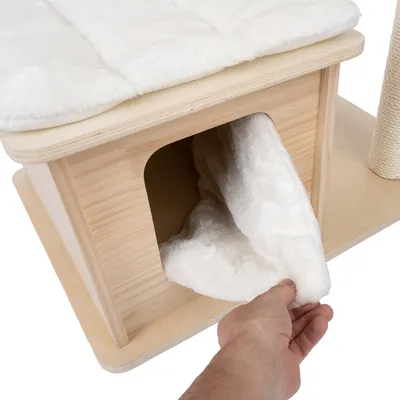Wooden house with white, soft cover. Hand lifts the cover to show the inside of the house.