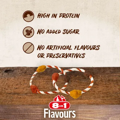 8in1 Flavours. High in protein, no added sugar, no artificial flavours or preservatives (text på engelska). Två tuggben i ringform med färgade ändar syns på träbord.