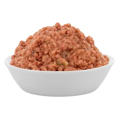 Skål med fuktig, finfördelad djurmat i rosa och bruna nyanser, synliga gröna och mörka bitar.