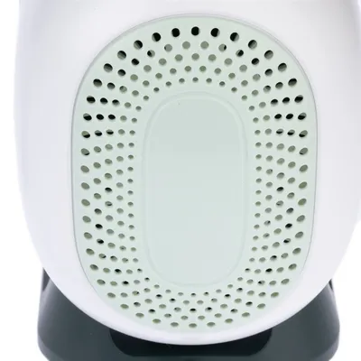 Close-up of a white device with a green, perforated area. Function or product name not visible.