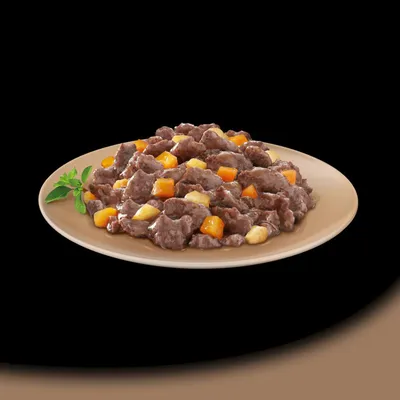 Plate showing chunks of meat in gravy with visible orange and light yellow vegetable pieces, presented for product content illustration.
