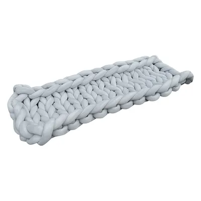 Tapis rectangulaire tressé en tissu gris clair, mailles épaisses visibles, sans marque apparente ni texte.
