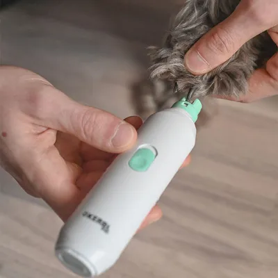 Elektrische Krallenschleifmaschine in weiss mit grünem Schalter, wird verwendet, um die Krallen eines Haustiers zu schleifen.