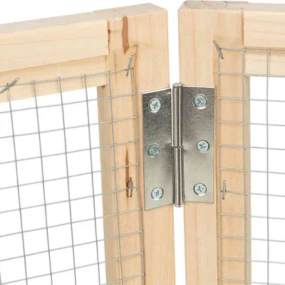 Vista dettagliata di una cornice in legno con griglia metallica e cerniera in acciaio inox, fissata con viti.