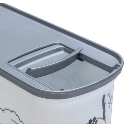 Grått lock med klafföppning på en vit behållare, dekorerad med djurmotiv och trädillustrationer.