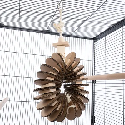 Jouet suspendu pour cage, composé de disques en carton et éléments en bois, accroché par une corde avec crochet métallique.