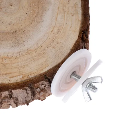 Disco de madera con corteza y fijación metálica, compuesta por tuerca de mariposa y discos de plástico.