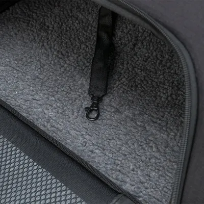 Innenansicht einer Tasche mit weicher, grauer Fleece-Polsterung und einem schwarzen Sicherheitskarabiner an einem Gurtband.