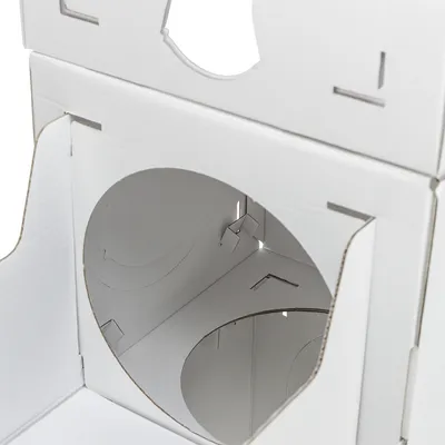 Weiße Kartonbox mit runden Öffnungen und Stecksystem, geeignet für Aufbau oder Lagerung.