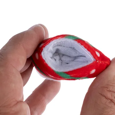 Nahaufnahme eines roten Stoffspielzeugs mit weissem Innenfutter, gehalten zwischen zwei Fingern. Sichtbare Details des Materials und der Öffnung.