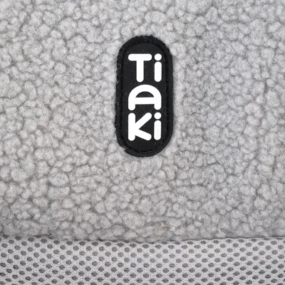 Tiaki – tissu gris effet laine bouclée avec maille filet visible en bas de l’image