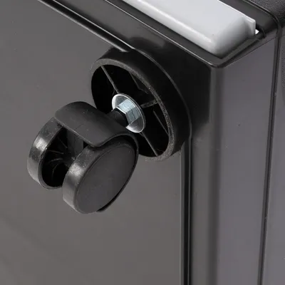 Close-up of a black plastic roller with metal mounting on a black housing.