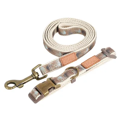 Beiges Hundehalsband und passende Leine mit Blattmuster, Metallverschluss und Lederdetails, Markenaufdruck 'Mac'.
