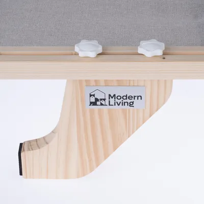 Modern Living-logotyp på en träställning med grått tyg och vita vridknappar.