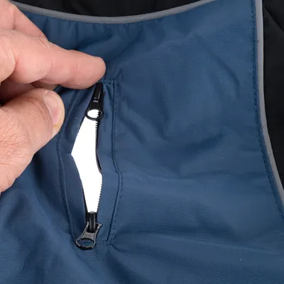 Close-up of blue fabric material with a black zip being opened.