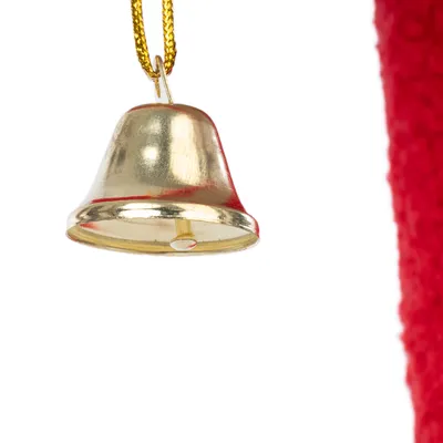 Clochette en métal doré suspendue à une cordelette jaune, fond partiellement rouge visible à droite.