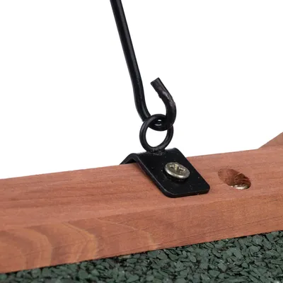 Primer plano de un gancho de metal negro fijado a un marco de madera. Tornillo y superficie verde visibles.