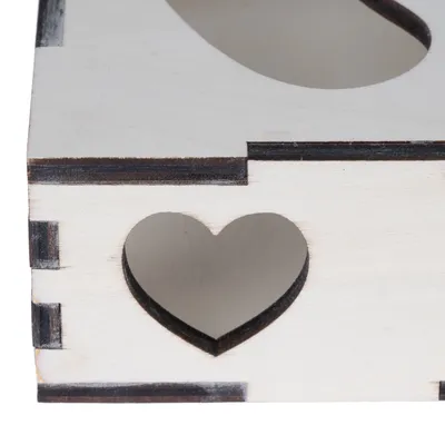 Boîte en bois clair avec ouverture en forme de cœur sur le côté, assemblage visible par emboîtement.
