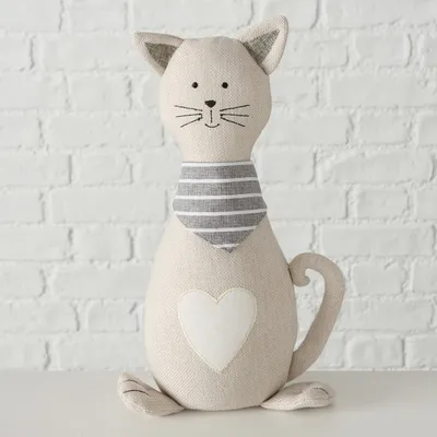 Dekorative Stoffkatze mit gestreiftem Halstuch und Herzmotiv auf der Vorderseite, beige Farbe, geeignet als Wohnaccessoire.