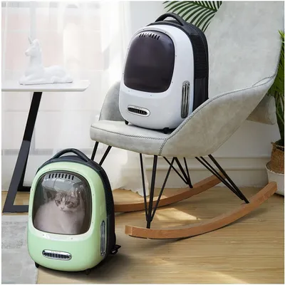 Deux sacs à dos de transport pour animaux, un vert avec un chat visible à l’intérieur et un blanc posé sur un fauteuil. Fenêtres transparentes et aérations visibles sur les deux sacs.