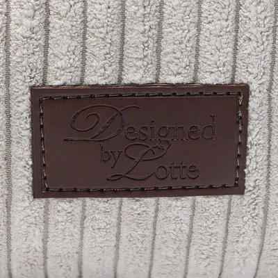 Designed by Lotte. Lædermærke på beige, ribbet stof.