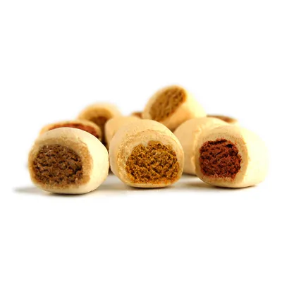 Nahaufnahme von gefüllten Hundesnacks mit verschiedenen Farben der Füllung: braun, orange und rot.