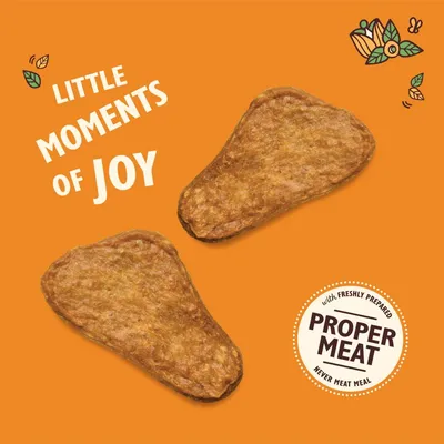 Two meat-shaped treats with text: 'Little moments of joy' and a badge stating 'with freshly prepared proper meat, never meat meal'.