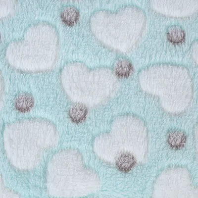 Détail de tissu pelucheux bleu clair avec motifs cœurs blancs et pois gris, matière douce visible, utilisé pour accessoires ou couchages pour animaux.