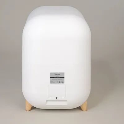 kooa. White container with wooden feet and CE marking, rear view with technical label.