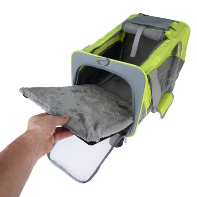 Transporttaske med grå, aftagelig pude. Hånd viser at puden tages ud af tasken. Taske i grå og neongul med netvinduer og bærehåndtag.