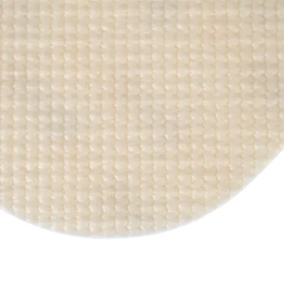 Gros plan sur une surface en tissu beige à texture quadrillée, matière douce et épaisse visible.