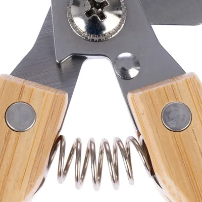 Nahaufnahme einer Schere mit Holzgriffen und Metallfeder, geeignet für präzises Schneiden.