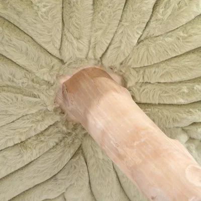 Vista detallada de un poste rascador de madera clara con acolchado de felpa suave y verde claro en la parte superior.