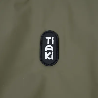 Tiaki. Markenlogo auf olivgrünem Hintergrund.