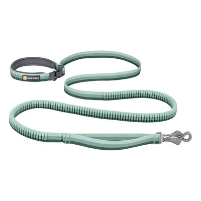 Trela verde claro Ruffwear com pega almofadada, fecho metálico e secção elástica visível. Marca Ruffwear identificada na pega.