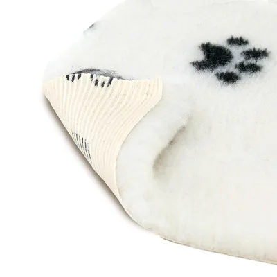 Close-up of a white mat with black paw pattern and non-slip underside made of ribbed material.