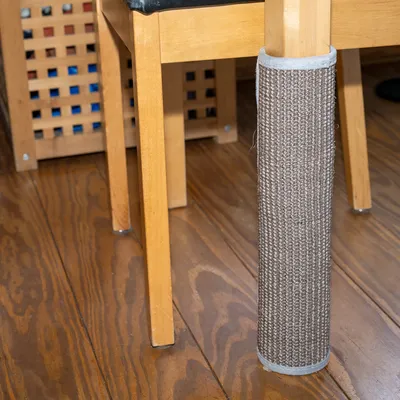 Kratzschutz aus Sisal für Tisch- oder Stuhlbeine, braun, befestigt an einem Holzstuhlbein.