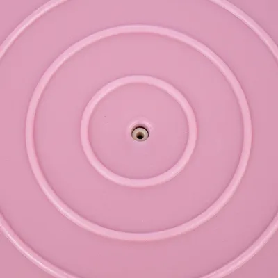 Superficie in plastica rosa con cerchi concentrici e apertura centrale.