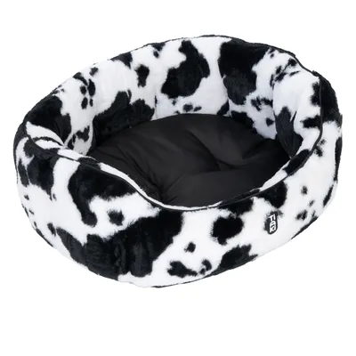 Round pet bed with black and white cow pattern and black inner cushion. Visible logo: Trixie.