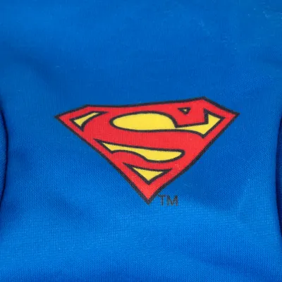 Logo Superman in rosso e giallo su sfondo blu.