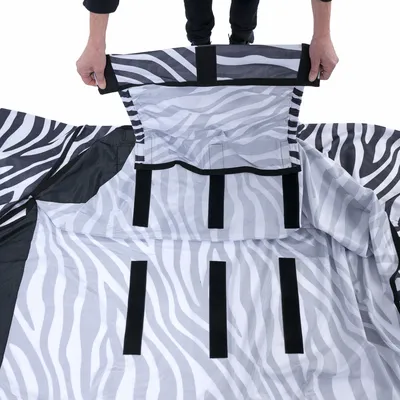 Tessuto a motivo zebra con più chiusure in velcro, tenuto da una persona. Mostra le possibilità di fissaggio del materiale.