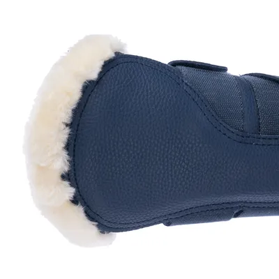 Vue rapprochée d’une botte pour chien en simili cuir bleu avec doublure intérieure en fausse fourrure blanche, fermeture à scratch visible.