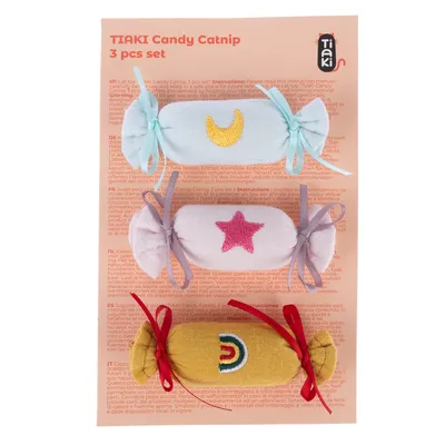 TIAKI Candy Catnip 3er-Set. Drei Stoffspielzeuge in Bonbonform mit Mond-, Stern- und Regenbogenmotiv. Anleitung auf Verpackung in mehreren Sprachen.