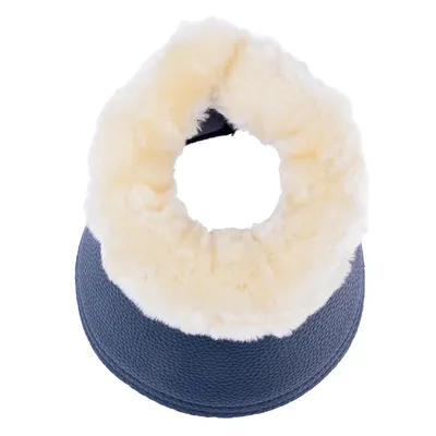 Coussin rond avec rebord en fausse fourrure crème et base en tissu texturé bleu foncé, vu du dessus.